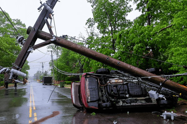 Power pole fallen on flipped car