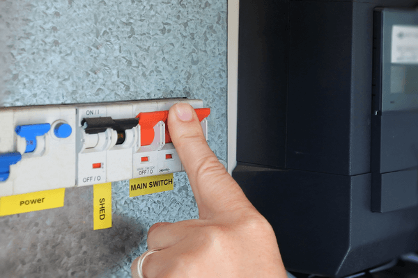 Electricity switchboard with finger on a switch