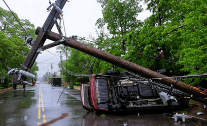 Power pole fallen on turned over car