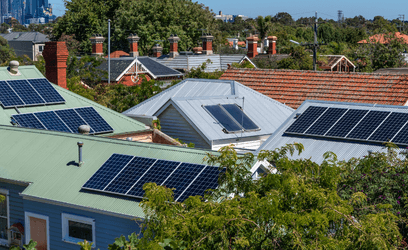 Solar panels on roofs with city in background